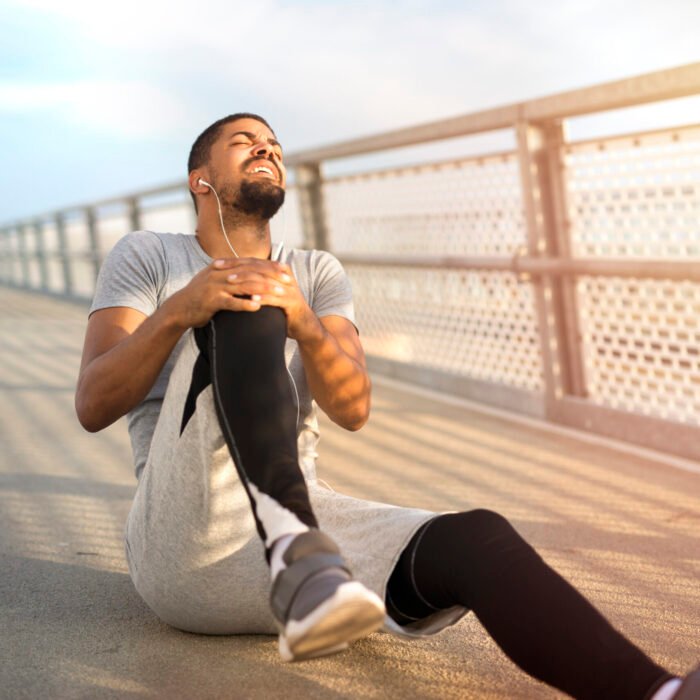 Sportsman having knee injury problem during running training.